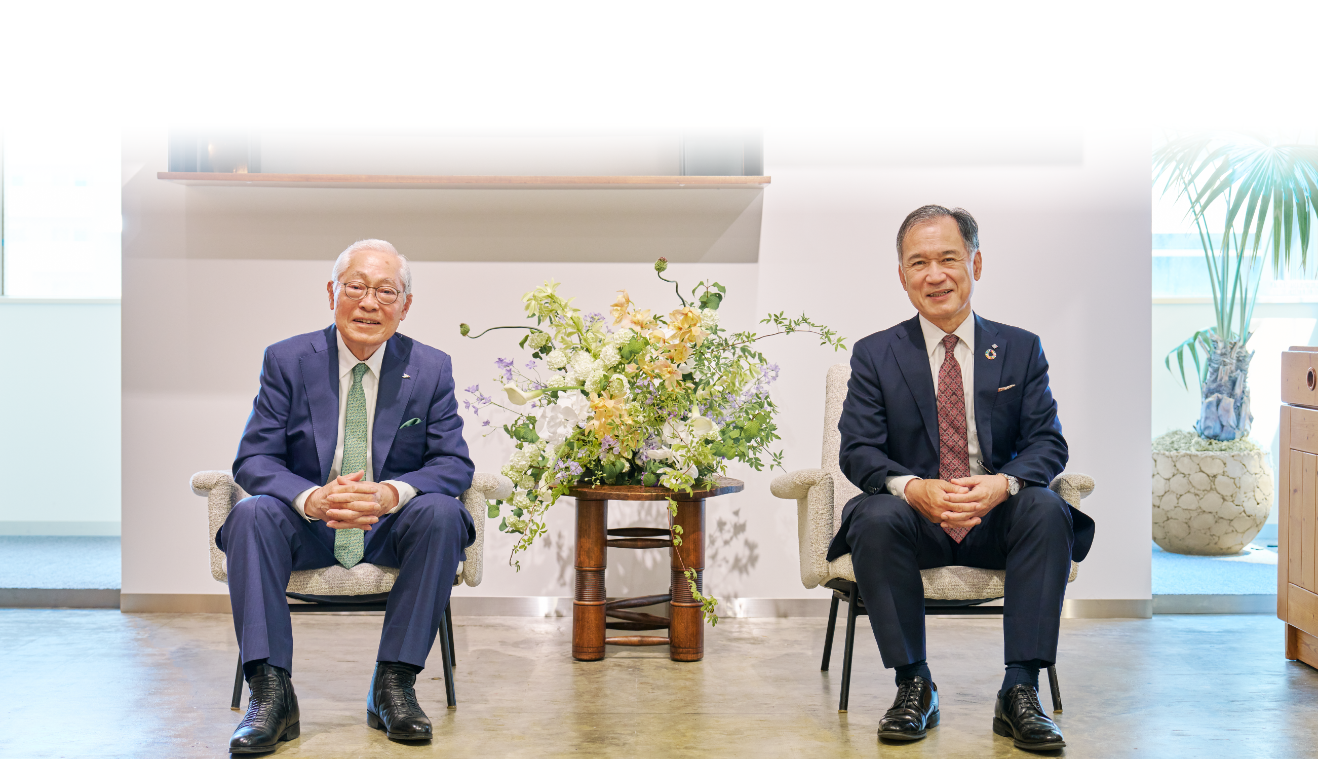 中国銀行頭取の加藤貞則氏と岡山土地倉庫会長の末長範彦氏が椅子に座り、穏やかな表情で対談している写真