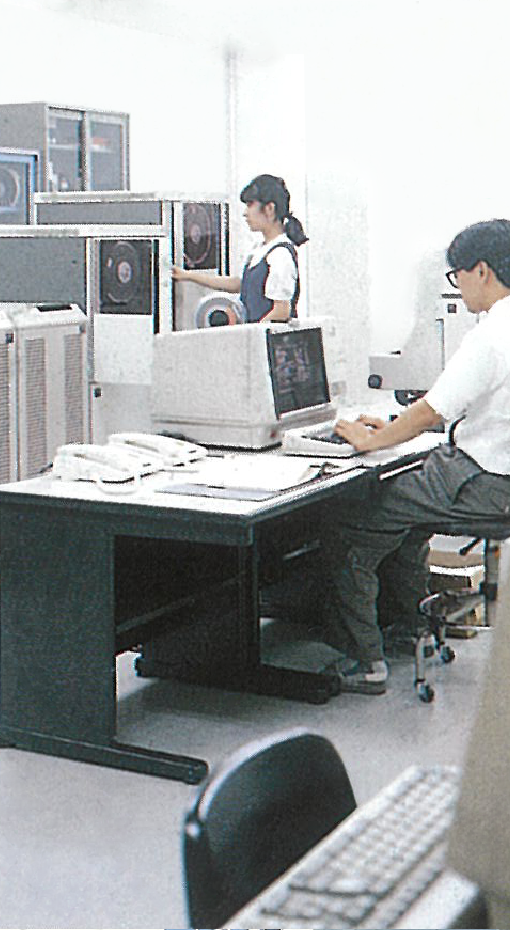 オフィス内でコンピューター作業をしている人々の写真